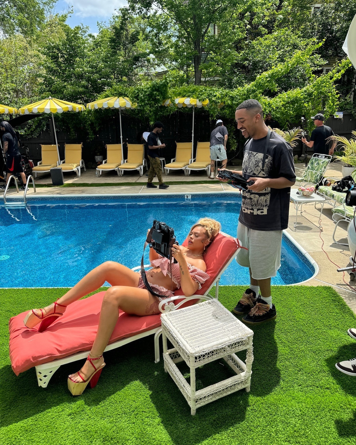 Jacob Webster and Latto reviewing imagery on set beside a pool
